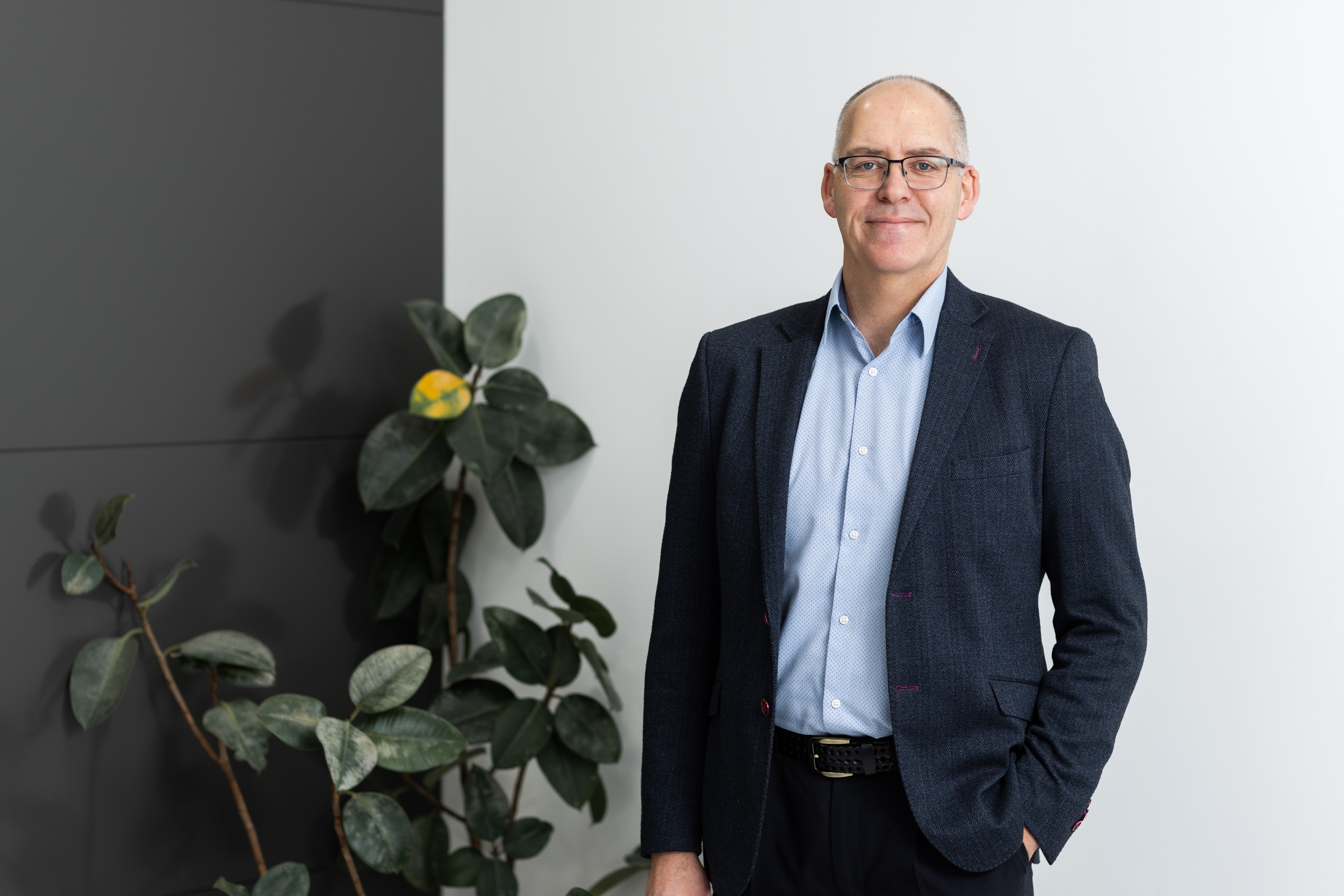 Jonathan Buesnel standing in office setting smiling